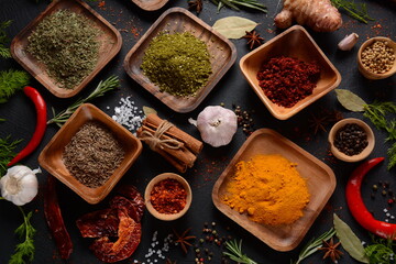 Variety of spices and herbs on kitchen table. Colorful various herbs and spices for cooking on dark background