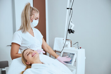 Dermatologist touching the screen of a beauty machine