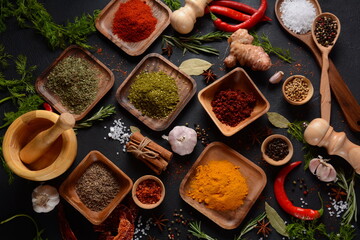 Variety of spices and herbs on kitchen table. Colorful various herbs and spices for cooking on dark...