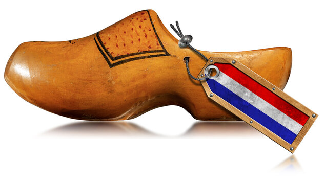 Closeup of a wooden clog made in Netherlands with Dutch flag and isolated on white background with reflections.