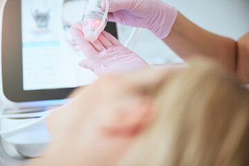 Obraz na płótnie Canvas Female doctor preparing the fractional microneedle machine for work