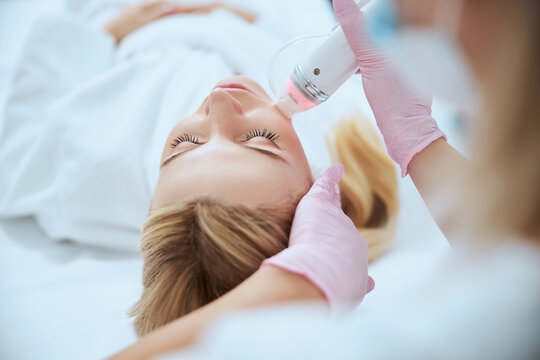 Dermatologist treating her patient with a beauty device