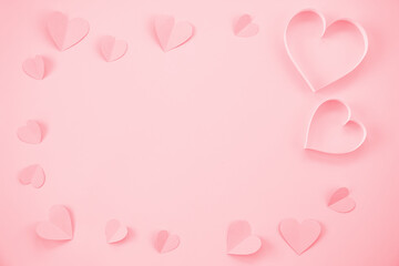 Paper cut hearts on pastel pink background. Composition for Valentine's Day, postcard. Flat lay, top view, copy space.