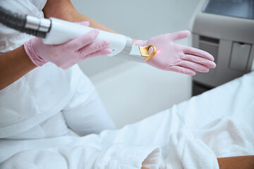 Dermatologist testing the beauty device before the procedure