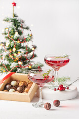 Obraz na płótnie Canvas Winter drink cocktail cranberry rosemary glasses white background box chocolates