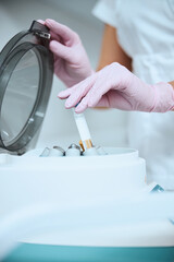 Cosmetologist using the laboratory equipment for a beauty procedure