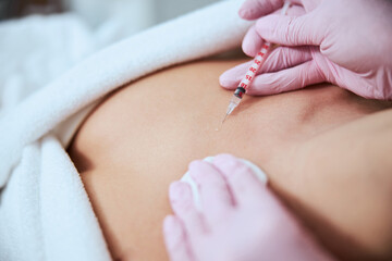 Female patient being injected into the decolletage area - obrazy, fototapety, plakaty