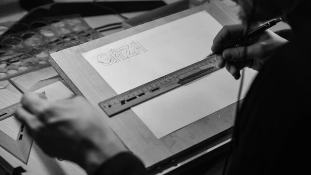The designer draws on a special drawing board. &ldquo;Qazaq eli&rdquo; is written on a sheet of paper. Translation: "Kazakh people". Timelapse.