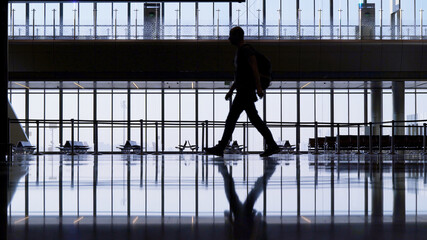 Fototapeta na wymiar A lone passenger in the big lobby of the airport. Airline Crisis