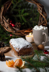 Fototapeta na wymiar Stollen - traditional German bread eaten during the Christmas season. Нomemade festive pastry dessert with dried berries, nuts and powdered sugar.