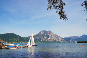 An einem schönen Sommertag Boote an Anlegestelle auf dem Traunsee, im Hintergrund der Berg Traunstein