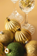 green and gold Christmas baubles on a beige background