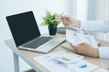 The businessman hand sits at their desks and calculates financial graphs showing the results of...