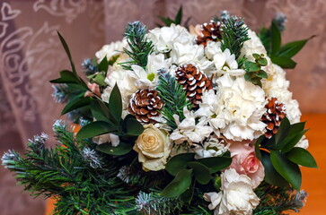 Christmas bouquet of carnations, roses, greenery and pine cones closeup