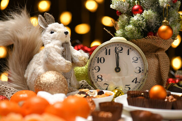 christmas or holiday decoration background - small fir tree, retro alarm clock shows midnight and...