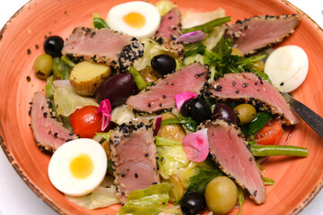salad with meat slices, potatoes, olives and boiled egg