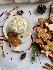 Winter cappuccino coffee in a white cup with man christmas gingerbread cookies. Christmas mood. New Year atmosphere. Cozy home.