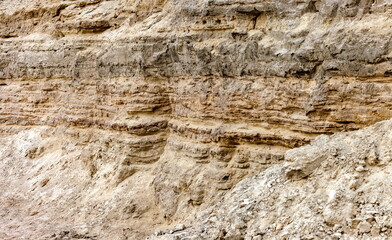 A precipitous wall of gray-brown sand in autumn. Background