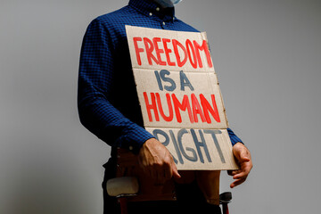 Freedom is a human right placard in hands of protester