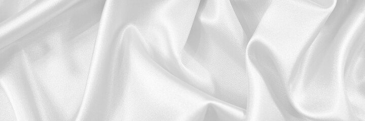 White silk satin fabric. White elegant background. Dark liquid wave or black silk with wavy folds....