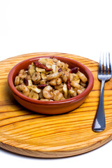 Prawns with garlic and cayenne in a ceramic bowl on a wooden tray