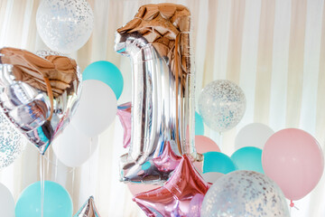 Pink, silver and blue inflatable balloons on ribbons - number 1. Decorations for birthday party. Metallic design balloon.