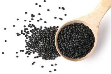 Black beluga lentils pile with wooden spoon isolated on white background, top view