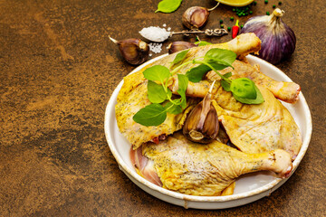 Organic raw chicken legs with spices, basil and garlic