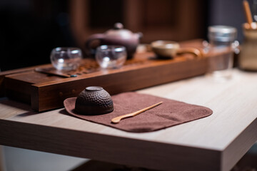 Clay tea cup and bamboo tea needle for picking tea cake on a special towel. Utensils for the tea ceremony close up