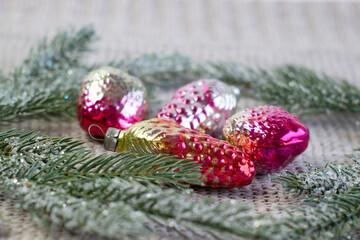 Old soviet decoration on the Christmas tree, glass toy strawberry and pine cone close up on knitted background