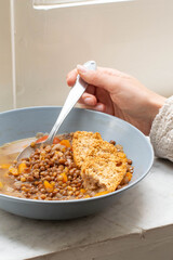 A grey/blue plate full of lentil soup