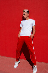 Image of handsome young smiling man standing isolated over red wall background.