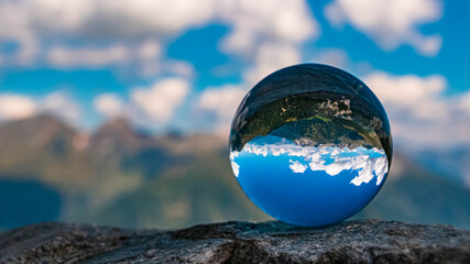 Crystal ball alpine summer landscape shot at the famous Timmelsjoch high alpine road, Dolomites, South Tyrol, Italy
