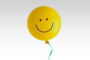 Yellow balloon with smile on white background - Concept of optimism and positive thinking - obrazy, fototapety, plakaty