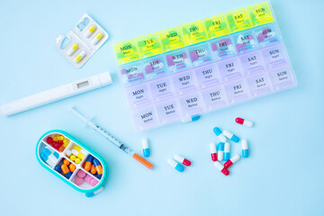 Plastic container with pills on blue background.