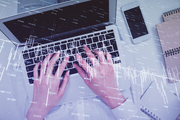 Double exposure of woman hands working on computer and forex chart hologram drawing. Top View....