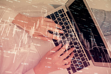 Double exposure of woman hands working on computer and forex chart hologram drawing. Top View. Financial analysis concept.