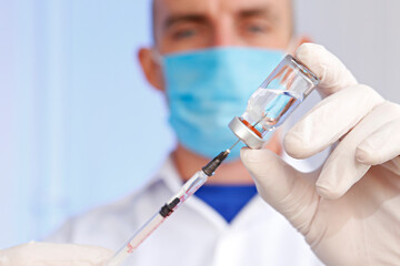 Macro shot of doctor's hands in latex gloves filling the syringe with new covid-19 vaccine from the vial. Close up, copy space, background. 