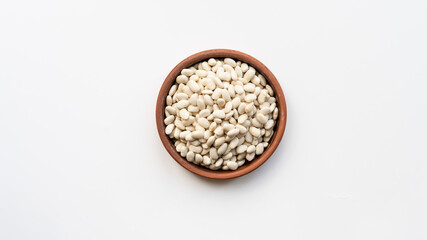 white beans in brown ceramic bowl. bowl of white kidney beans. navy, cannellini bean on white background isolated top view photo