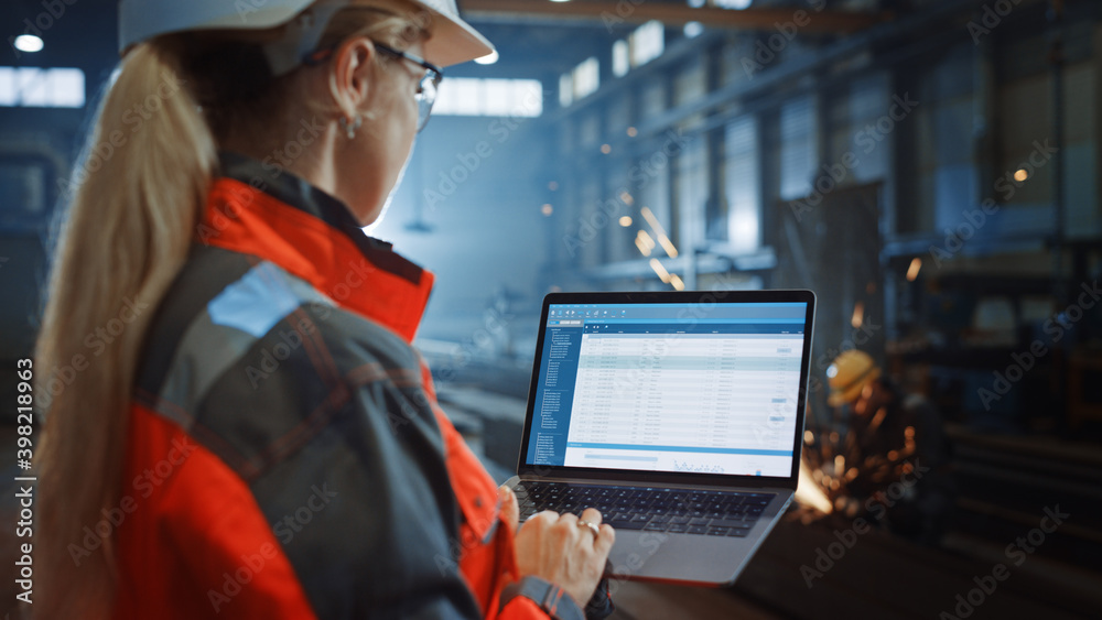 Poster professional heavy industry engineer uses laptop computer with administrative data cataloging softwa