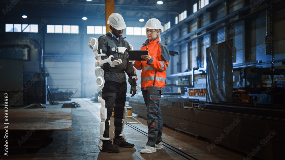 Aufkleber engineer and manual labor worker in a bionic exoskeleton prototype check development test results on