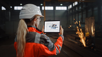 Professional Heavy Industry Engineer Uses Tablet Computer for Augmented Reality Render with Interactive Turbine Engine Blueprint. Female Industrial Specialist Working in a Metal Manufacture Warehouse.