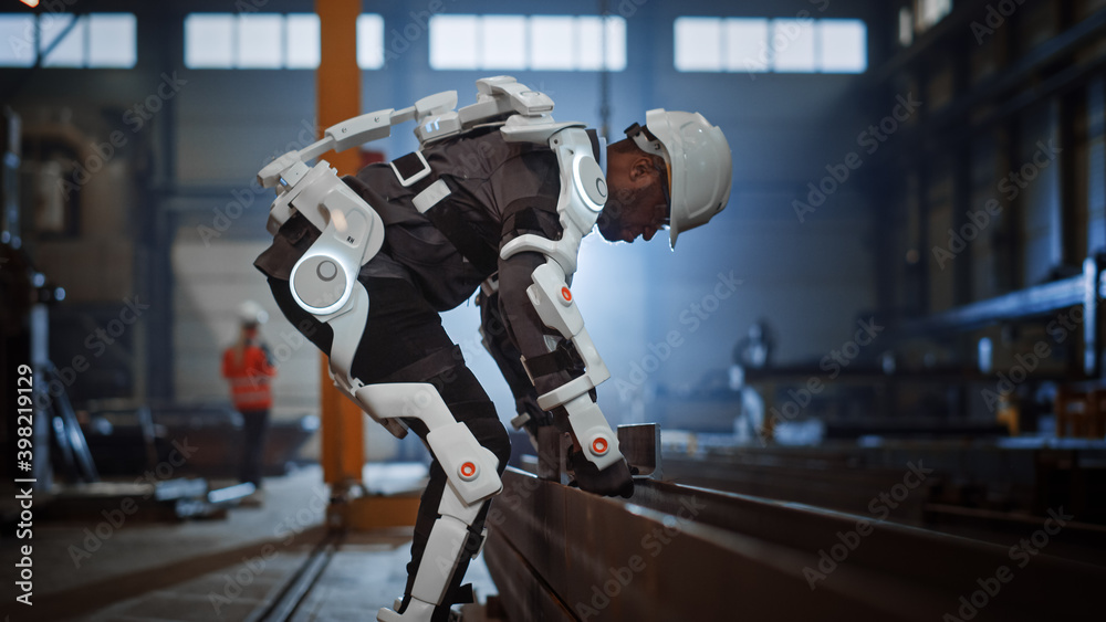 Poster black african american engineer is testing a futuristic bionic exoskeleton and picking up metal obje