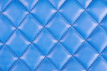 Fototapeta premium Modern luxury car blue leather interior. Part of perforated leather car seat details. Blue perforated leather texture background. Texture, artificial leather with diagonal stitching. Leather seats