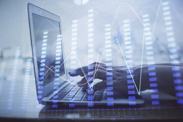 Double exposure of woman hands typing on computer and forex chart hologram drawing. Stock market...