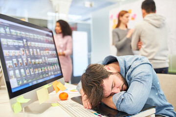 Graphic designer sleeps exhausted in front of the computer