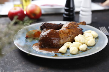 Roast duck with apples in a roast sauce with dumplings.
Appetizing dish served on a plate. culinary photography, food styling.