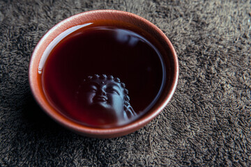 image of tea cup buddha reflection