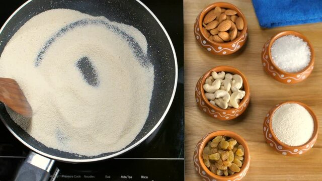 Female's hand roasting Sooji/semolina in a non-stick frying pan to prepare Halwa. Suji/Sooji Halwa preparation with raisins/Kismis  almonds/Badam  cashew nuts/Kaju  and sugar in containers - Indian...