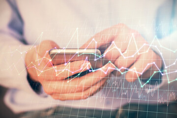 Multi exposure of man's hands holding and using a digital phone and forex graph drawing. Financial market concept.